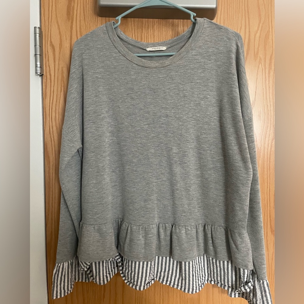 Grey light weight sweater with ruffle bottom.